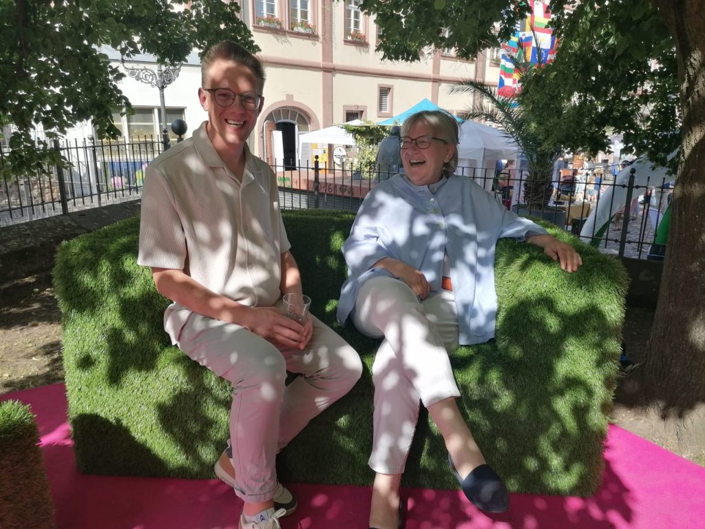 Gut gelaunt: Dorothee Wüst, Kirchenpräsidentin der Evangelischen Kirche der Pfalz mit Moderator Jonathan Danigel auf der "grünen Couch" beim Demokratiefest Neustadt.
